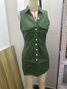 Detail view of a green denim sleeveless shirt dress on a mannequin with chest pockets.