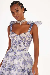 Elegant white organza evening dress with blue floral print, featuring bow straps and corset bodice