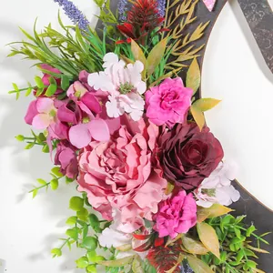 Vista macro dei dettagli di peonie e rose artificiali rosa su una ghirlanda a luna