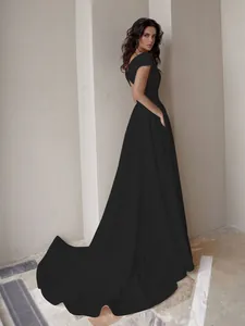 Elegante vestido de noche negro con espalda descubierta y una larga cola fluida de gala