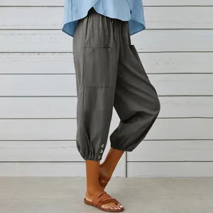Close-up of casual grey cotton-linen cropped pants with drawstring and button cuffs.