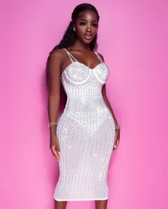 Vista completa di un abito midi bianco aderente trasparente decorato con strass.