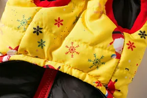 Macro detail of festive yellow pet vest with Christmas Santa and snowflake patterns.