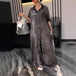 Macro view of distressed gray denim shirt dress featuring white letter print and button-down front