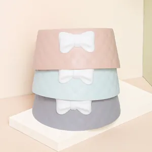 Elegante gestapelte Macaron-Haustiernäpfe mit weißen Schleifen und dekorativer Rautenstruktur.