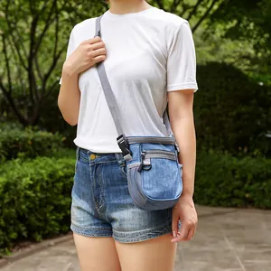 Petit sac de dressage bleu denim porté en bandoulière dans un décor extérieur