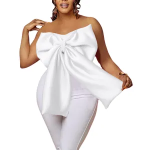 Dettaglio di elegante top a fascia bianco satinato con fiocco oversize per donna