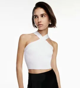Detailed view of the white ribbed knit halter neck top with cross-front design