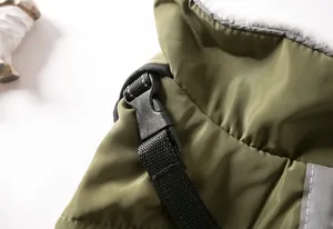 Macro detail of dog winter jacket showing buckle, reflective strap, and faux fur lining