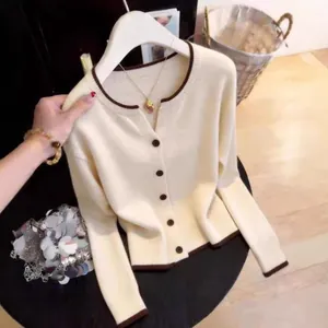Elegant cream-colored knitted cardigan with brown contrast trim and buttons for women