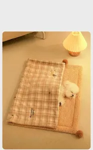 Comfortable plaid pet blanket with warm plush mat and soft pompom details for small dogs