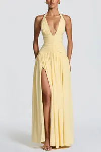 Full length view of a yellow deep V-neck halter maxi dress with a sexy high leg slit