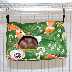Vista di un'amaca calda in peluche con motivo a volpe verde appesa in una gabbia per animali