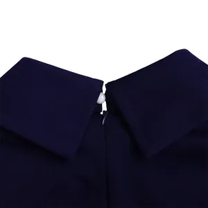 Detail of navy blue dress collar with white pearl button and hidden back zipper
