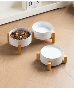 Cuencos de cerámica blanca para mascotas con soporte de bambú en un hogar moderno
