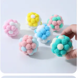 Close-up of colorful macaron plush cat toy balls held by hand to show size and texture