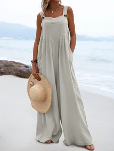 Elegante mono de verano sin mangas con pernera ancha y botones mostrado en la playa