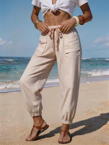Detail of striped drawstring beach pants featuring pockets and elastic cuffs