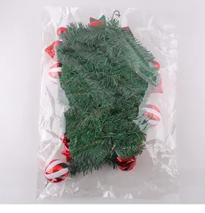 Kunstmatige kerstslinger met rode ornamenten in een heldere transparante zak