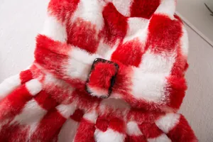 Primer plano detallado del vestido de felpa a cuadros rojos y blancos para perros.