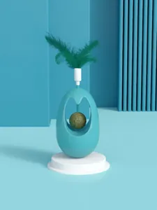 Detail shot of the blue cat tumbler toy featuring a catnip ball and green feather