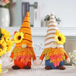 Coppia di gnomi di peluche per la festa del raccolto con girasoli e foglie d'acero.