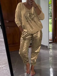 Women's two-piece leisure set with long-sleeve sequin eye top and metallic gold pants