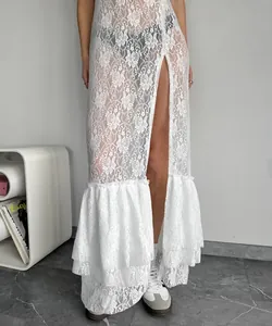 Detailed view of an elegant white floral lace maxi dress with a high slit and ruffled hemline.