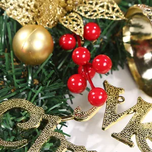 Close-up of festive Christmas wreath with red berries, gold baubles and pine needles