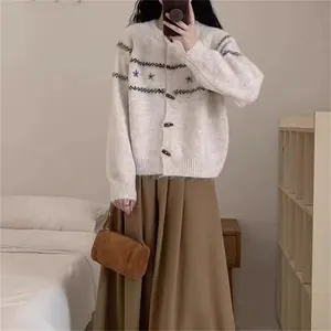 Detalle de cárdigan de punto crema para mujer con botones de cuerno y bordado de flores