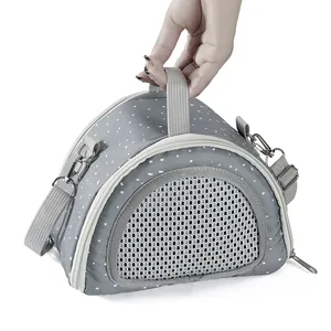 Detailed view of grey polka dot small pet carrier bag being held by hand