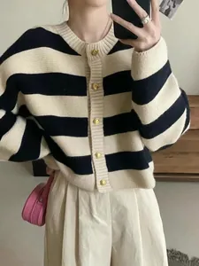 Detailed view of women's black and cream striped knit cardigan with gold buttons