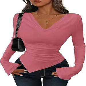 Detail of pink long-sleeve slim-fit top featuring a stylish asymmetrical hem and V-neckline