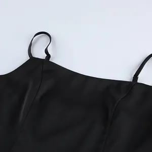 Close-up of black satin camisole top showing neckline and adjustable thin straps.