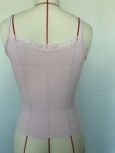 Detailopname van een roze geribbeld hemdje met de elegante kant op de rugzijde
