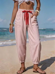Close-up of summer striped drawstring joggers in a sunny beach vacation setting