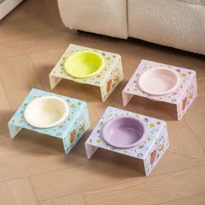 Four ceramic pet food bowls with slanted patterned acrylic stands in green blue pink and purple