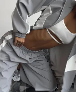Detailed close-up of a two-piece grey and white paneled tracksuit set on a model
