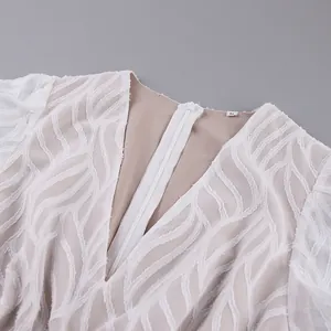 Detailansicht der Jacquard-Textur und des V-Ausschnitts dieses weißen Kleides im französischen Stil