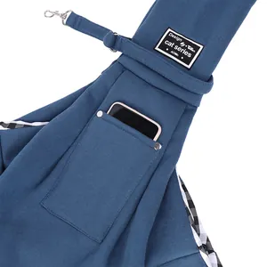 Détail d'un sac de transport bleu pour animaux avec une poche pour téléphone et étiquette