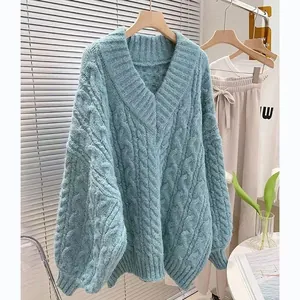 Vista dettagliata di un maglione blu a trecce con scollo a V in uno stile invernale accogliente