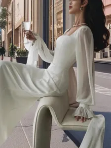 Elegant long sleeve white mermaid wedding gown with U-neck for outdoor photography shoot