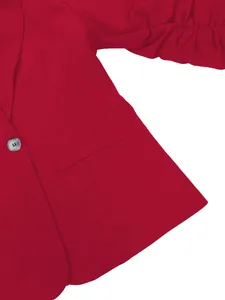 Gros plan d'un blazer rouge professionnel pour femme avec manches volantées et bouton