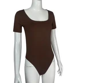 Close-up view of a dark brown ribbed short sleeve yoga bodysuit shown on a white mannequin