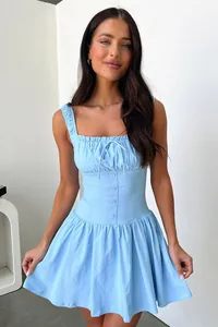 Détail de la robe sans manches bleu clair avec taille ajustée et buste froncé.