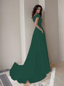 Vista trasera de un elegante vestido largo verde esmeralda con cola larga y diseño calado