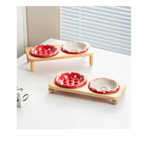 Vue détaillée des gamelles en céramique champignon rouge avec un support en bois de chêne.