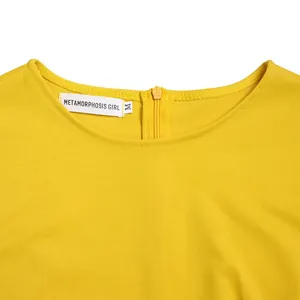 Nahaufnahme des gelben Bleistiftkleid-Ausschnitts mit Markenetikett und Reißverschluss.
