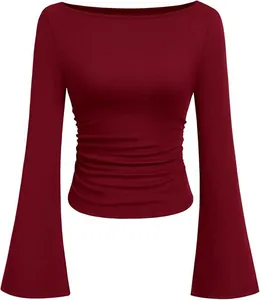 Elegante wijnrode top met lange mouwen, boothals, gerimpelde taille en klokmouwen.