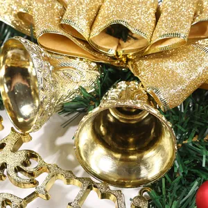 Close-up detail showing golden Christmas bells and a glitter bow on a green wreath